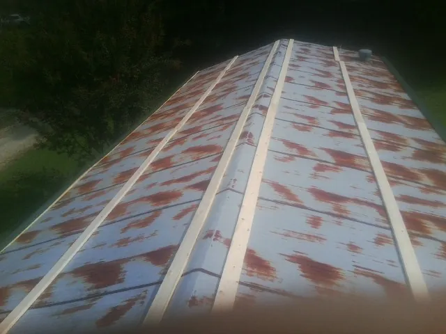 Rusted metal roof panels with new wood purlins before replacement — Storm Damage Roof Repair in Exeter by Roofing Brothers
