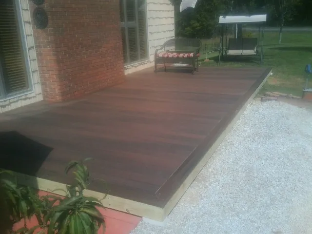 Freshly stained wood deck built against a brick home in Exeter