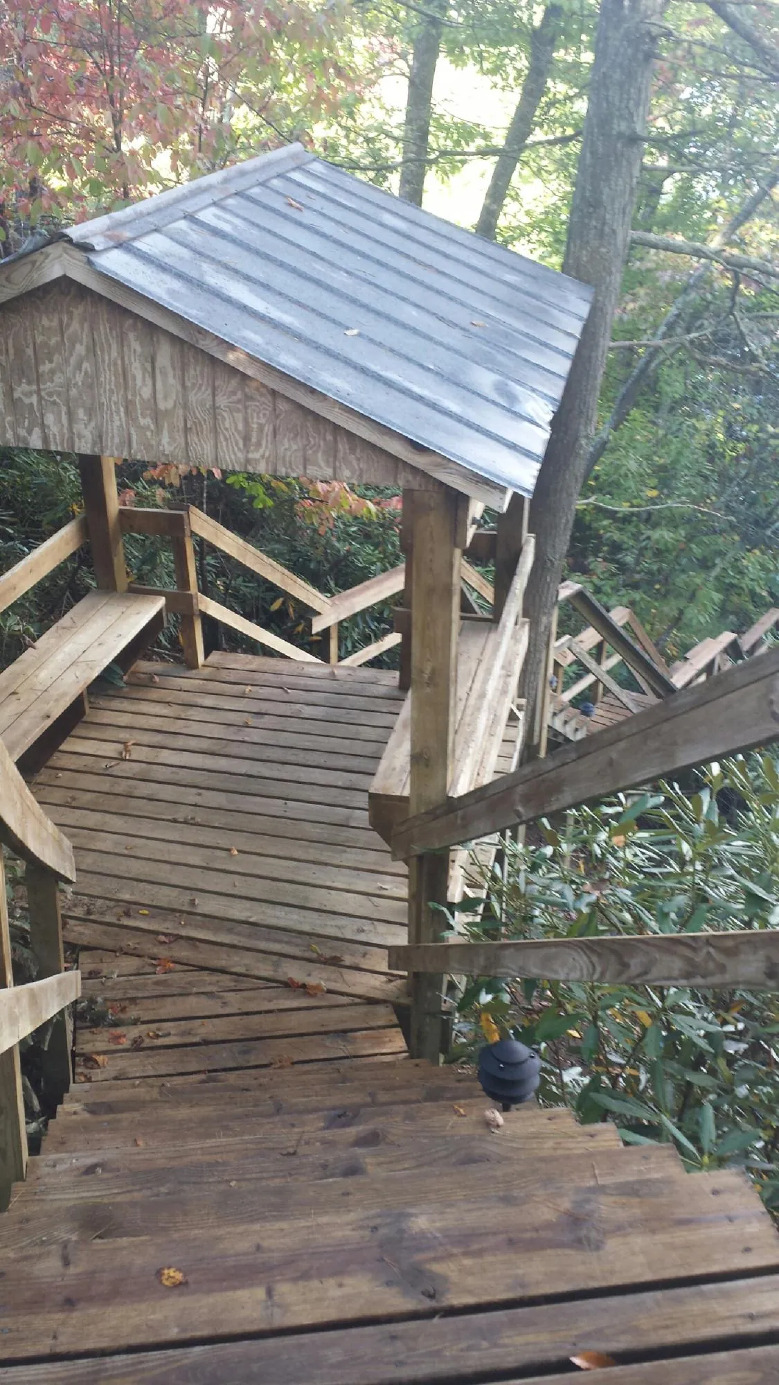 Metal roofed shelter over wooden steps on a wooded walkway — Skylight Repair & Installation work by our crew in Exeter